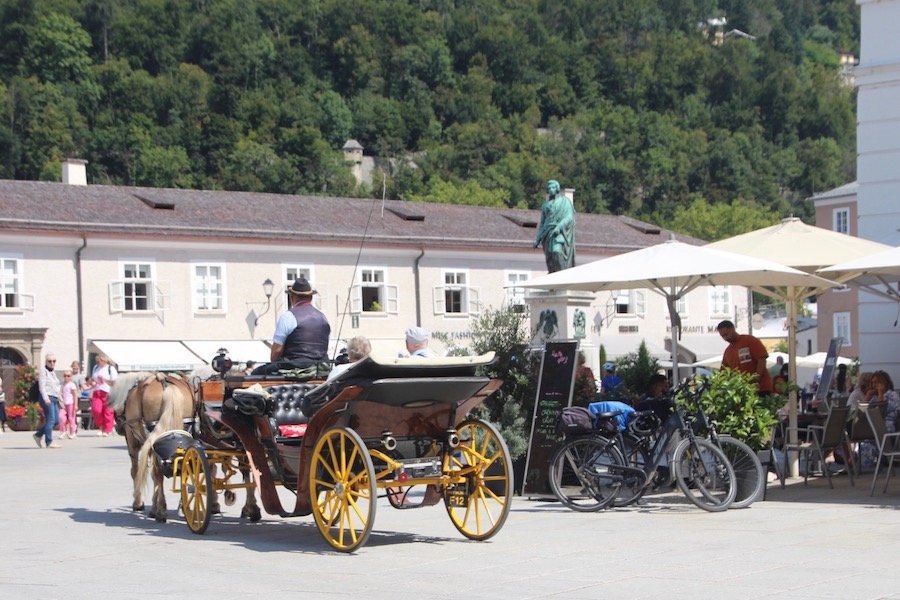 Konzentrat in Salzburg: Fiaker, Domplatz und Mozartdenkmal im Hintergrund