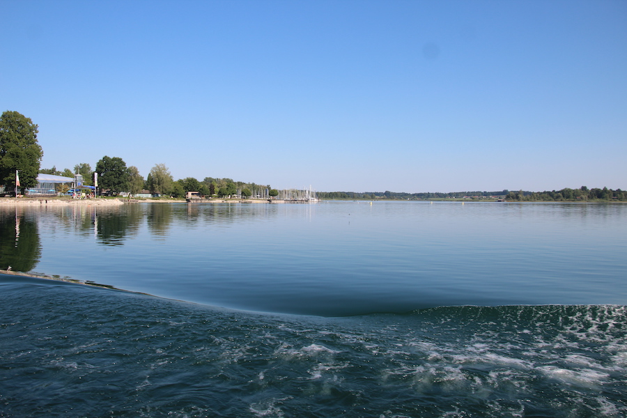 Der Chiemsee ist spiegelglatt und nur die Bugwelle sorgt etwas für Bewegung.