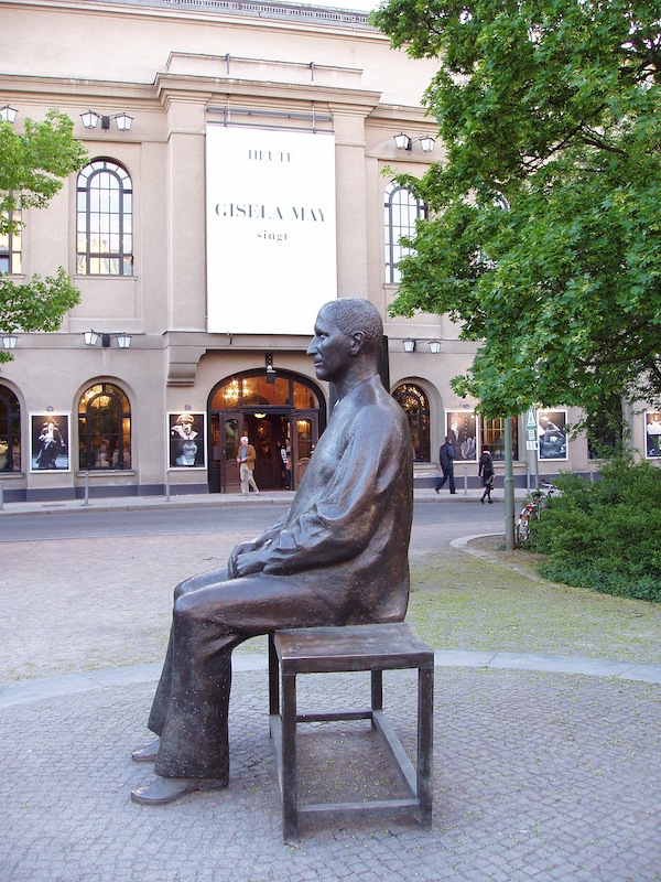 Brecht als Denkmal, auf der Bank sitzend.